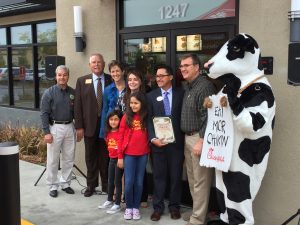 Glendora City Council poses with owner Carlos Mayen and his family and a very relieved cow, a funny symbol of Chick-fil-A marketing.